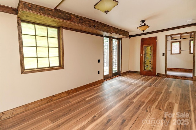 spare room with hardwood / wood-style floors and crown molding