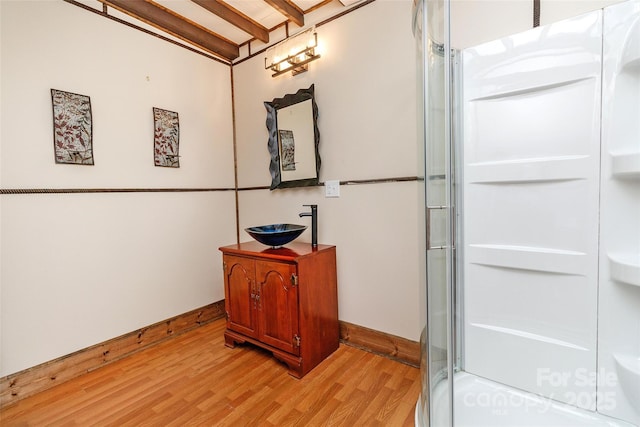 bathroom featuring hardwood / wood-style floors, walk in shower, and vanity