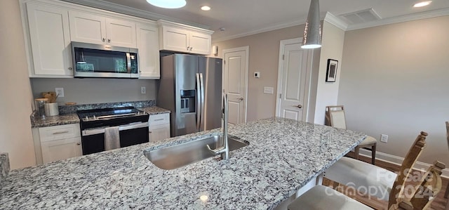 kitchen featuring white cabinets, crown molding, sink, a breakfast bar area, and appliances with stainless steel finishes