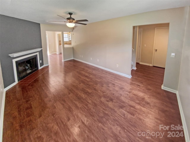 unfurnished living room with dark wood-type flooring and ceiling fan