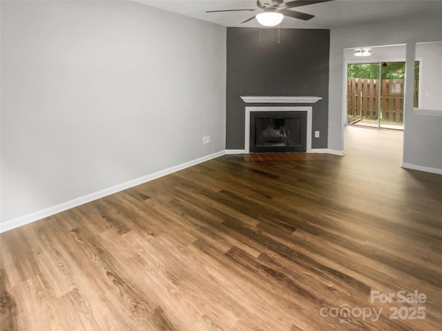 6003 Heath Valley Rd, Charlotte, NC 28210 - unfurnished living room featuring ceiling fan, wood finished floors, a fireplace, and baseboards