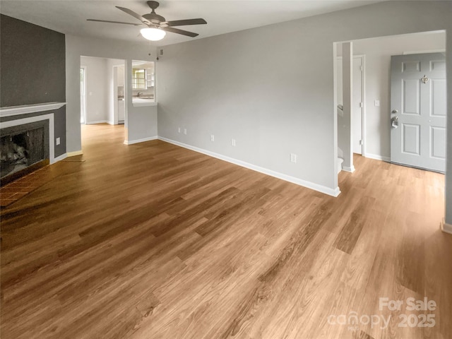 6003 Heath Valley Rd, Charlotte, NC 28210 - unfurnished living room featuring ceiling fan, wood finished floors, baseboards, and a fireplace