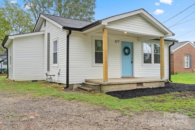 view of front facade with covered porch, roof with shingles, and crawl space