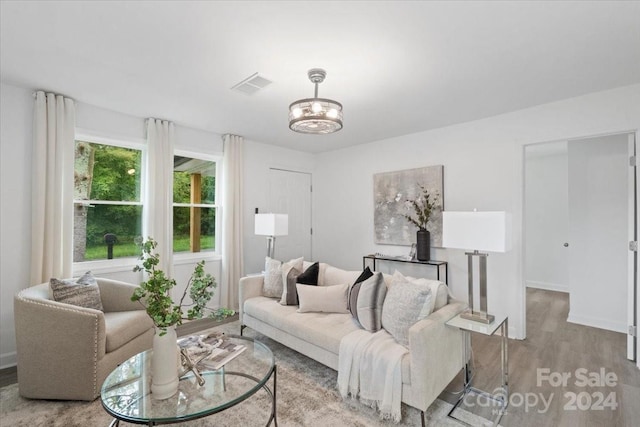 living area with baseboards, visible vents, and light wood-style floors