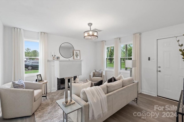 living room featuring a healthy amount of sunlight, light hardwood / wood-style flooring, and an inviting chandelier