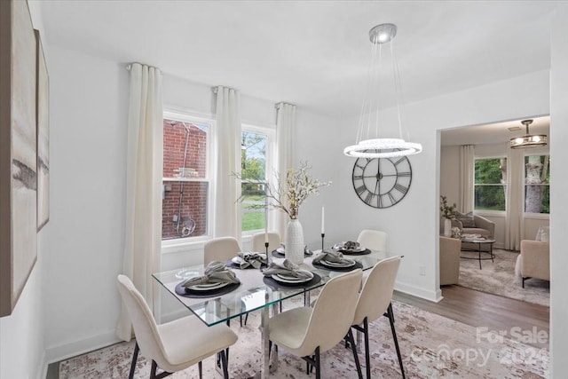 dining space featuring baseboards and light wood finished floors