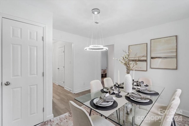 dining area with light wood-type flooring and baseboards