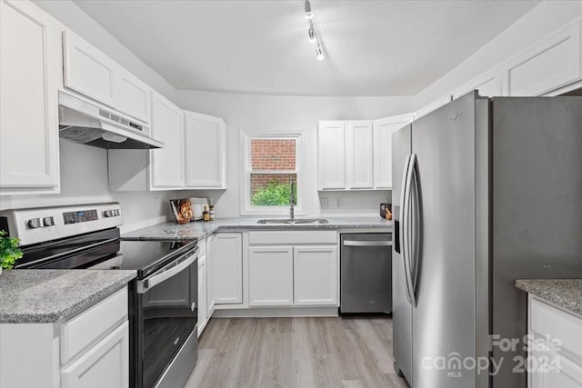 kitchen featuring white cabinets, under cabinet range hood, and stainless steel appliances