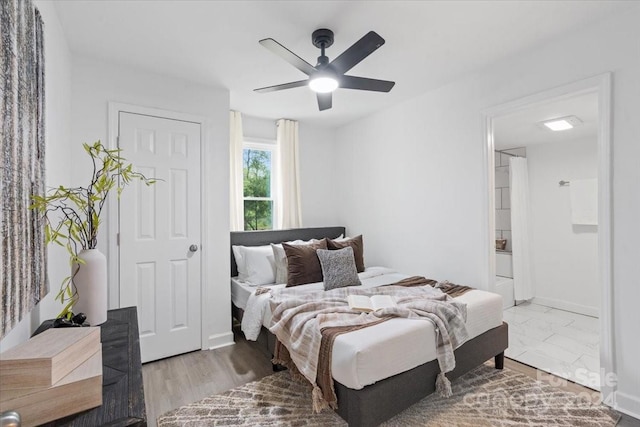 bedroom featuring ensuite bath, a ceiling fan, and baseboards