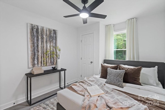 bedroom with ceiling fan, wood finished floors, and baseboards