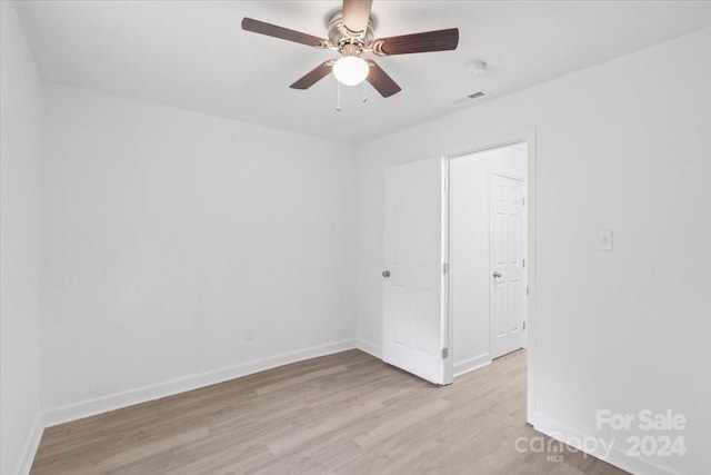 unfurnished room featuring baseboards, ceiling fan, visible vents, and light wood finished floors