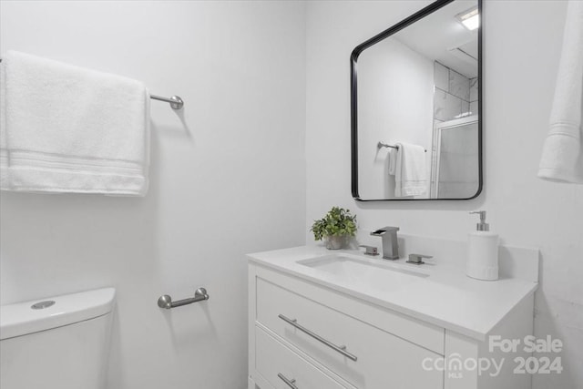 bathroom featuring vanity, toilet, and an enclosed shower