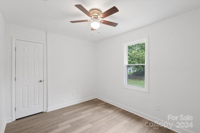 unfurnished room featuring a ceiling fan, baseboards, and light wood finished floors