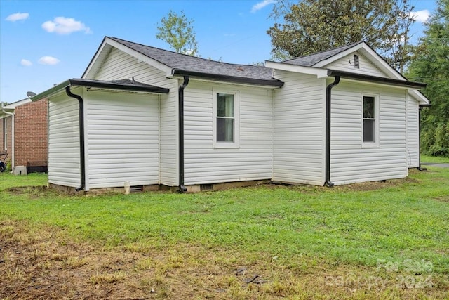 view of side of home featuring crawl space and a lawn