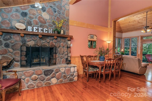 dining area with hardwood / wood-style flooring, high vaulted ceiling, wooden ceiling, and a fireplace