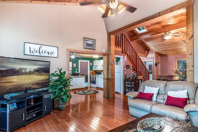 living room featuring wood-type flooring, high vaulted ceiling, wooden ceiling, beamed ceiling, and ceiling fan