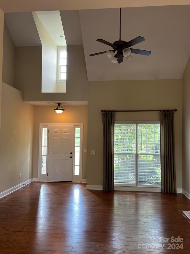 foyer with ceiling fan, high vaulted ceiling, and dark hardwood / wood-style flooring