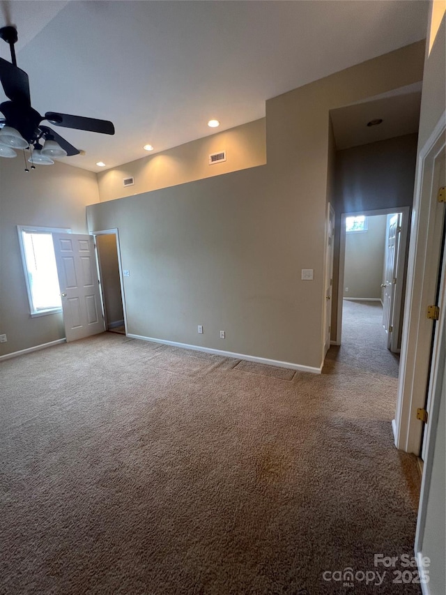 carpeted spare room featuring ceiling fan