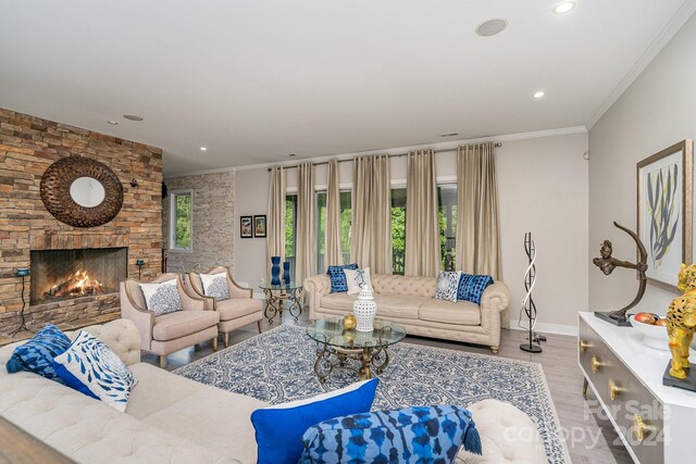 living room with a fireplace, light hardwood / wood-style flooring, and ornamental molding