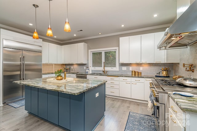 kitchen with high end appliances, white cabinetry, a center island, pendant lighting, and island exhaust hood