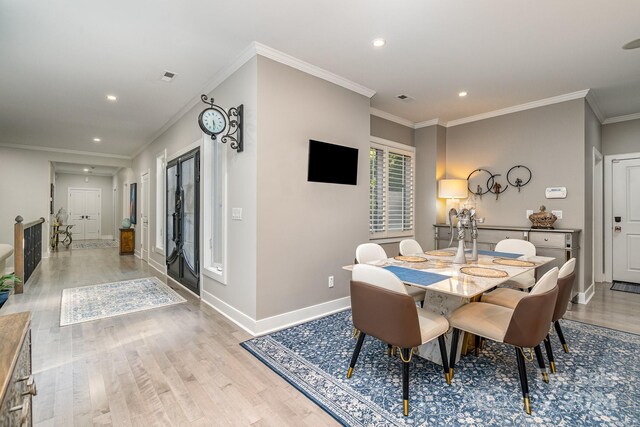 dining space with crown molding and light wood-type flooring