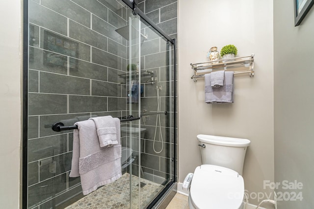 bathroom with a shower with door and toilet