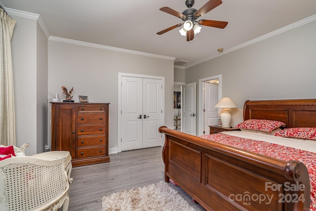 bedroom with crown molding, light hardwood / wood-style floors, a closet, and ceiling fan