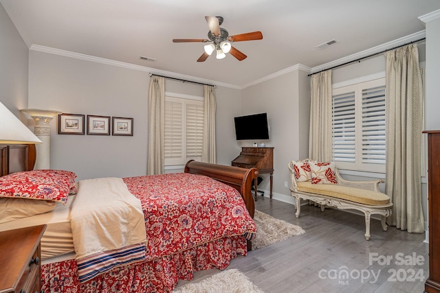 bedroom with crown molding, hardwood / wood-style floors, and ceiling fan