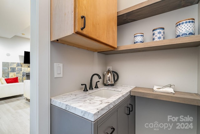 laundry room with hardwood / wood-style flooring and sink