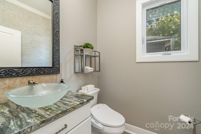 bathroom with vanity, toilet, and ornamental molding