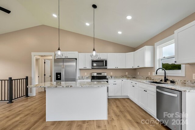 kitchen featuring appliances with stainless steel finishes, light wood-type flooring, and hanging light fixtures