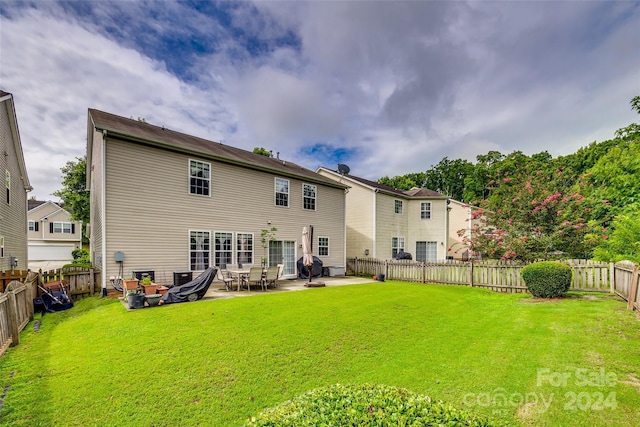 back of house featuring a patio area and a yard