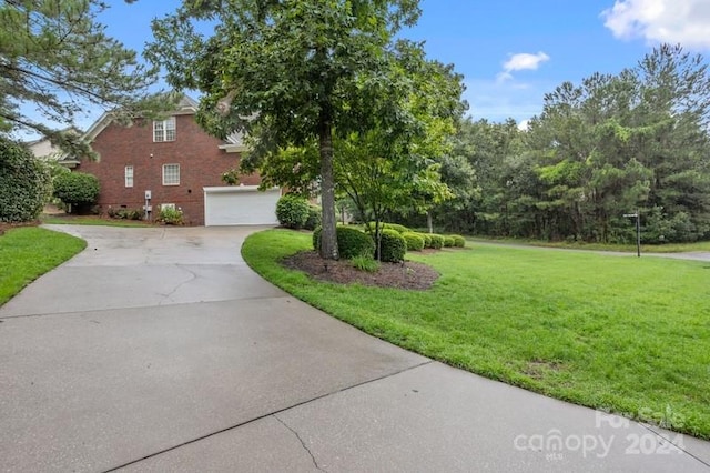 view of front of home featuring a garage, concrete driveway, and a front yard