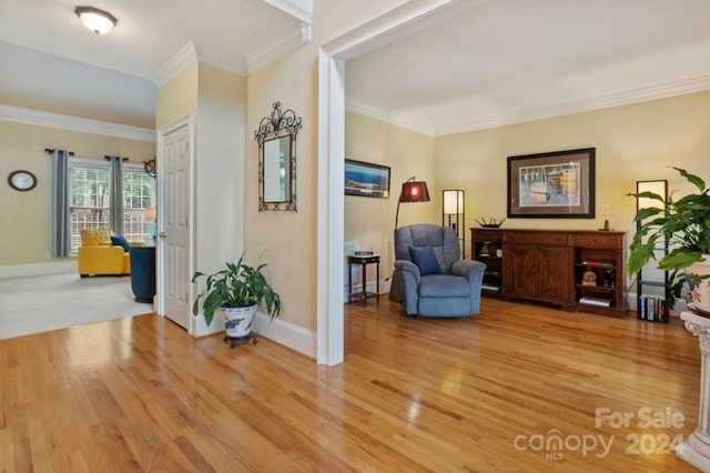 living area featuring light hardwood / wood-style floors and crown molding