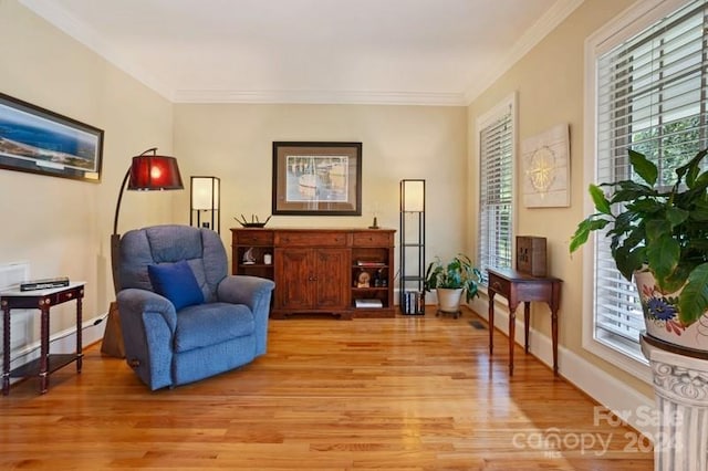 sitting room with light hardwood / wood-style floors and ornamental molding