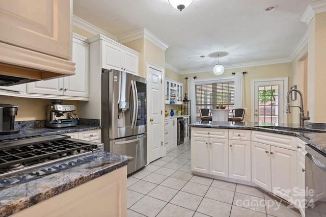 kitchen with white cabinetry, stainless steel appliances, crown molding, and sink