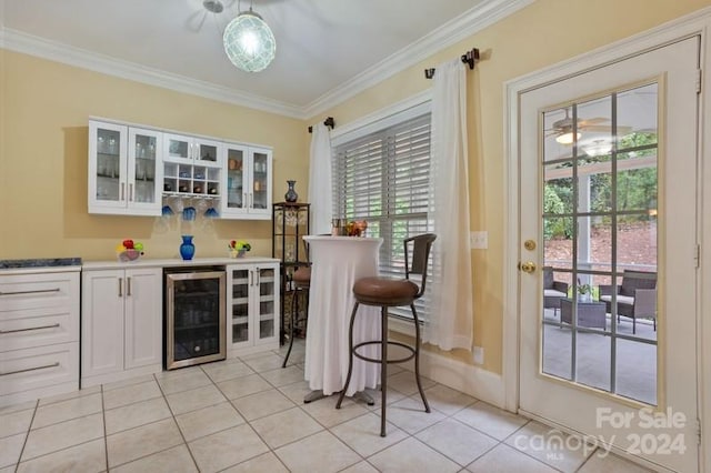 bar with white cabinetry, crown molding, light tile patterned floors, and wine cooler