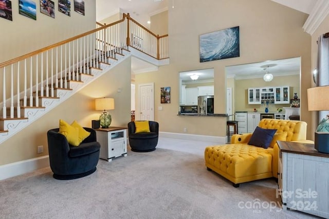 carpeted living room featuring crown molding and a high ceiling