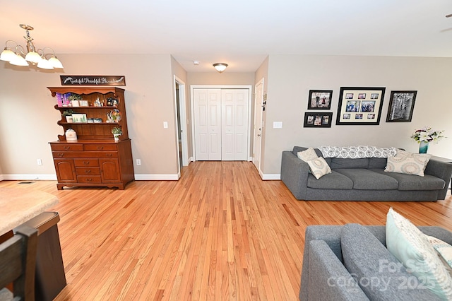 living room featuring a notable chandelier and light hardwood / wood-style floors