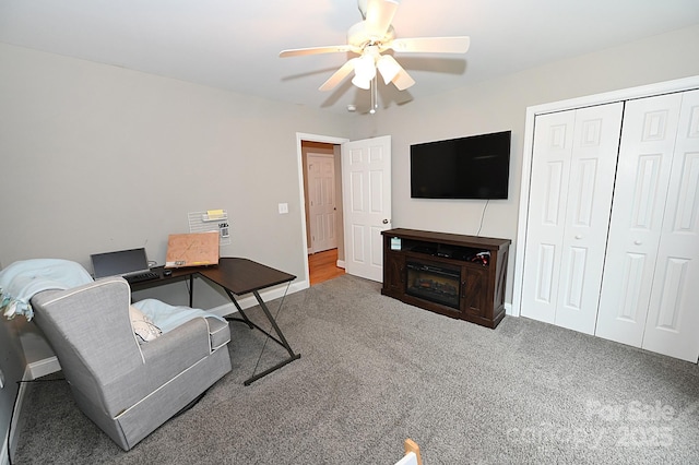 carpeted office space featuring ceiling fan