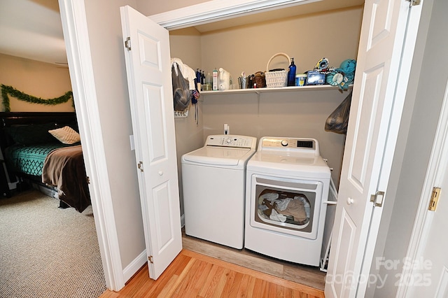 laundry area featuring washer and clothes dryer and light hardwood / wood-style flooring