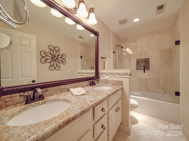 full bathroom featuring dual vanity, toilet, tile patterned floors, and tiled shower / bath