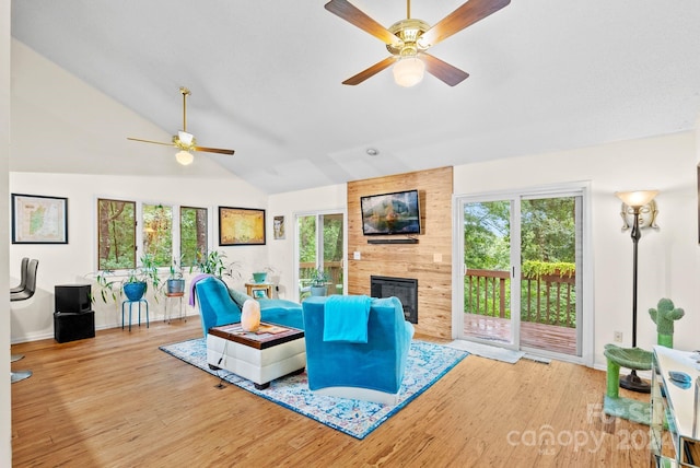 living room featuring visible vents, a ceiling fan, lofted ceiling, wood finished floors, and a fireplace