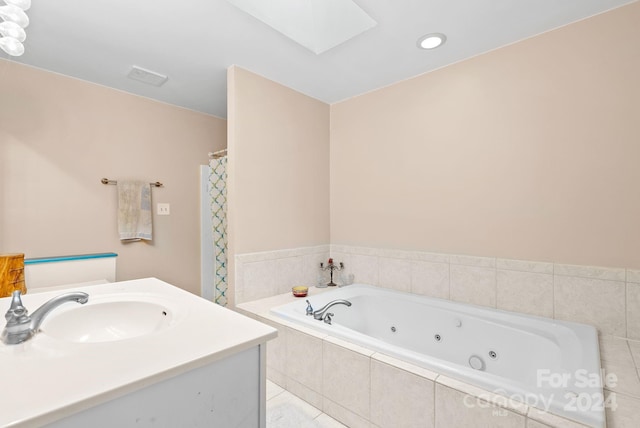 full bathroom featuring a skylight, visible vents, vanity, a whirlpool tub, and tile patterned floors