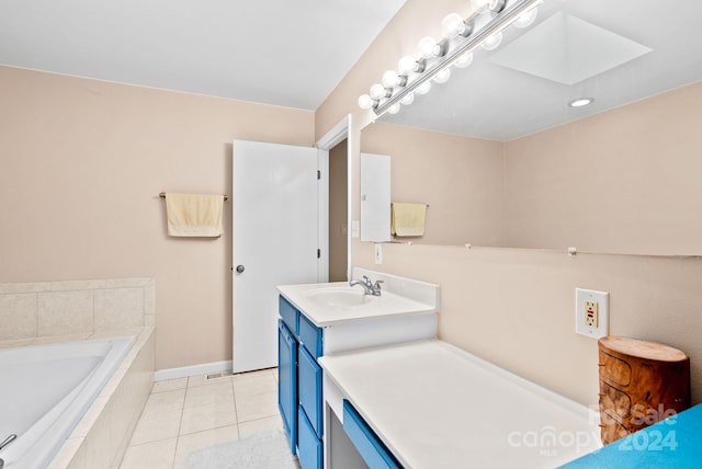 full bathroom with a relaxing tiled tub, a skylight, baseboards, tile patterned flooring, and vanity