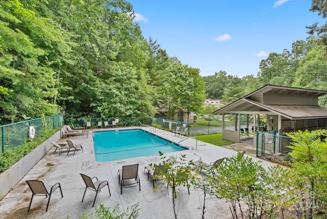 community pool featuring fence and a patio