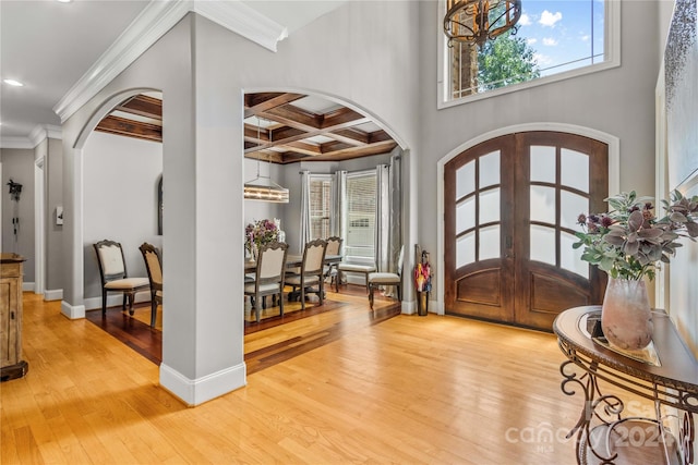 entrance foyer featuring beamed ceiling, light hardwood / wood-style flooring, french doors, crown molding, and coffered ceiling