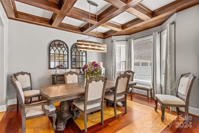 dining room with beam ceiling, coffered ceiling, and hardwood / wood-style flooring