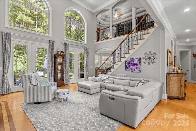 living room featuring crown molding, light wood-type flooring, french doors, and coffered ceiling