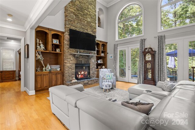 living room with a fireplace, french doors, and light hardwood / wood-style floors